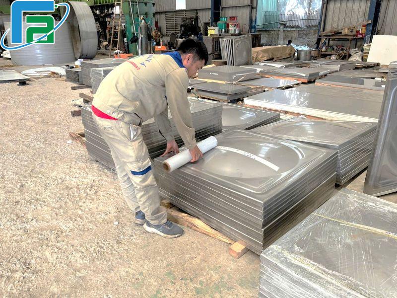 Kỹ thuật đang kiểm tra các tấm ghép inox đã được dập khuôn cho bể nước lắp ghép tại nhà máy cơ khí Toàn Á