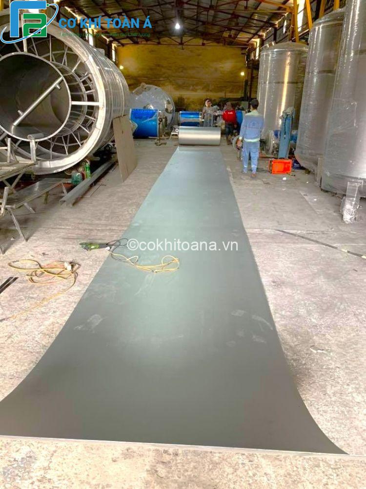 Cơ Khí Toàn Á: Sản Xuất Bồn Lọc Áp Lực Inox Cao Cấp 2025 5 Các công nhân đang trải các cuộn inox để làm phôi chuẩn bị sản xuất các Bồn lọc áp lực theo đơn đặt hàng